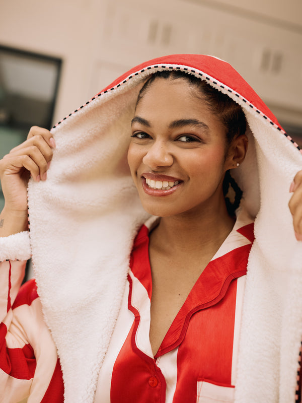 woman wearing red and white striped borg lined robe with a hood