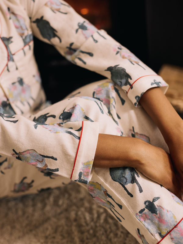 woman wearing soft brushed cotton white pyjamas with sheep pattern 