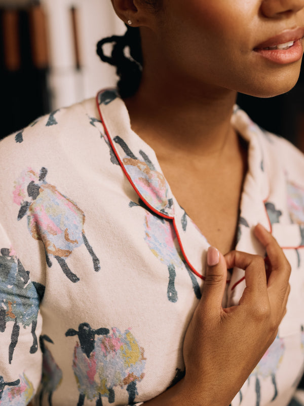 woman wearing soft brushed cotton white pyjamas with sheep pattern 