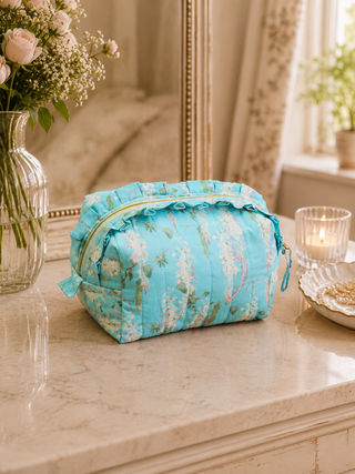 Floral wisteria toiletry bag on a marble surface with decorative elements