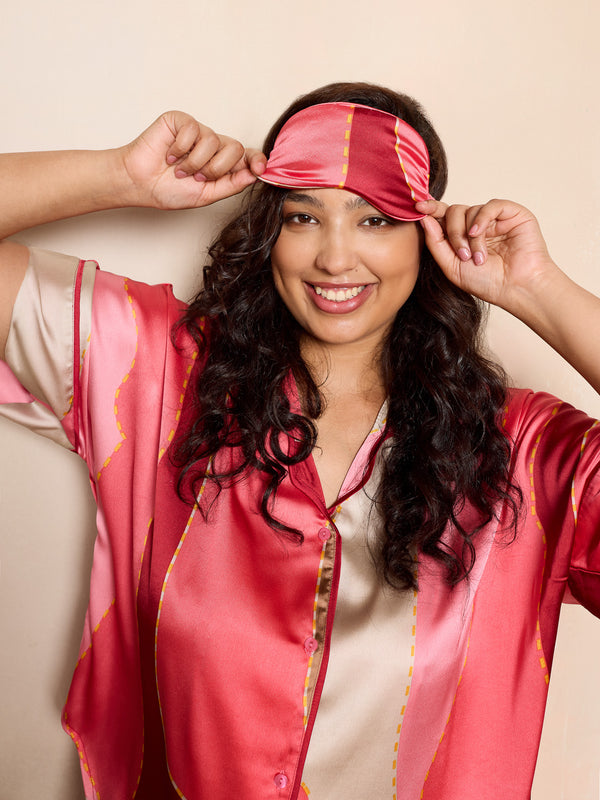 woman wearing pink satin pyjamas and matching eyemask