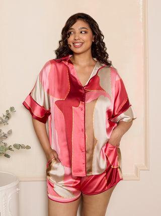plus size woman wearing pink oversize satin pyjama short set