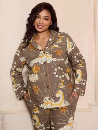 Woman wearing a grey celestial pyjama set in a bedroom