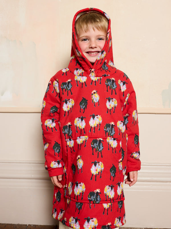 Child wearing a red hoodie with sheep pattern against a beige background