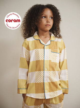 Child model wears yellow gingham pumas with blue contrast trim
