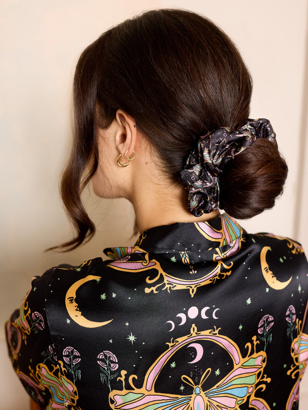 woman wearing black satin scrunchie with celestial pattern in her hair