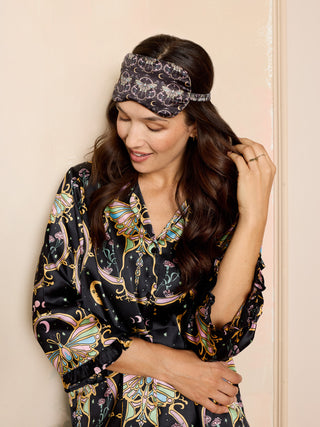 woman wearing black satin eye mask with mystical moth print