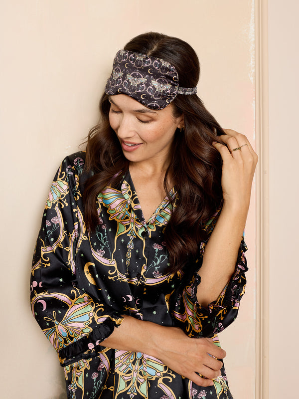 woman wearing black satin eye mask with mystical moth print