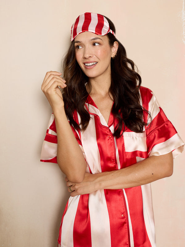 woman wearing red and white striped satin pyjamas and matching eye mask