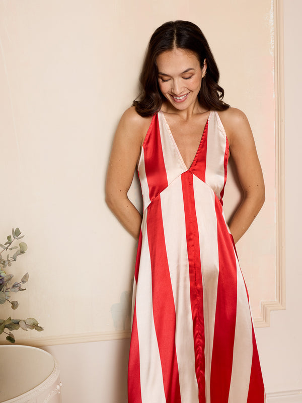 Woman wearing a red and white striped night dress against a neutral background