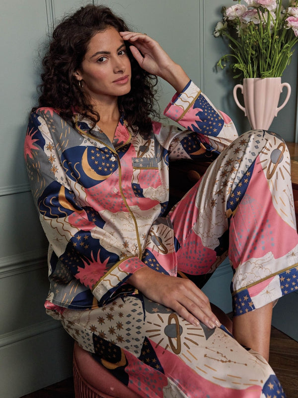 Model wears celestial print long pyjamas in a bedroom