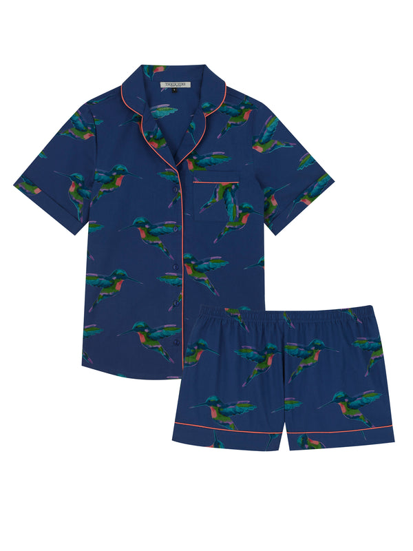 Flat shot of Navy based ladies shortie pyjamas, with repeating hummingbird pattern in alternating directions, pink piping detail on shorts cuffs and collar