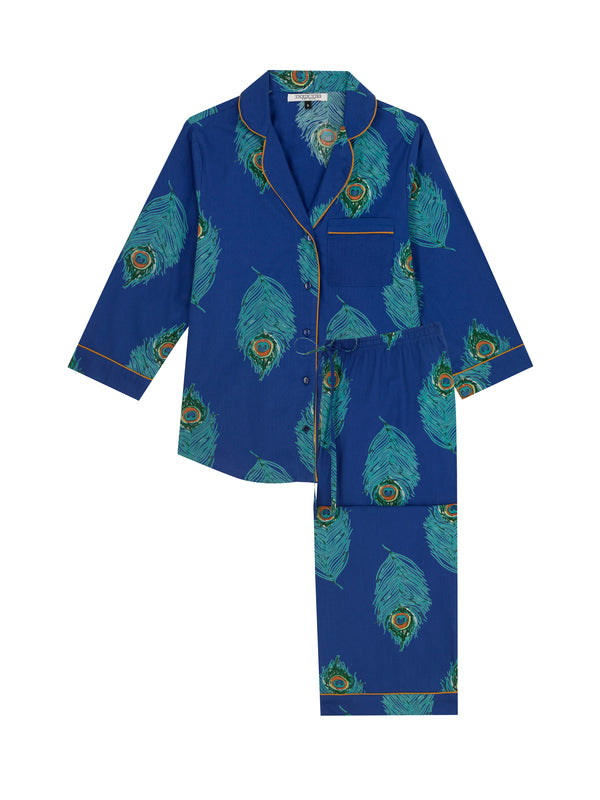 Flat shot of Navy based ladies traditional cotton capri length pyjamas, with repeating green peacock feather pattern, orange piping on cuffs and collar